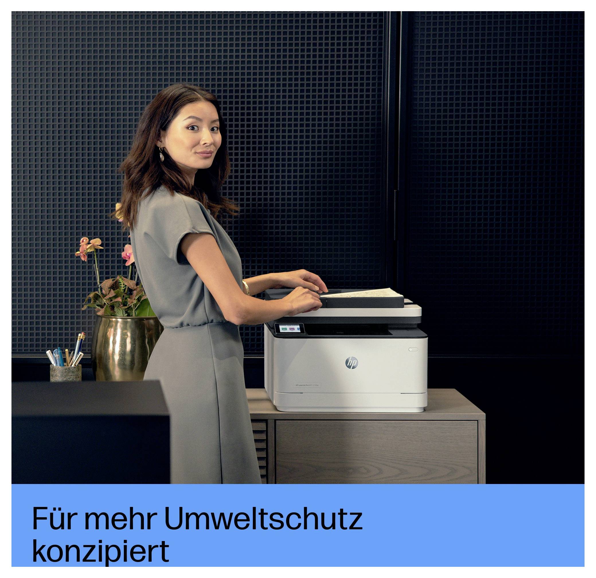 Femme utilisant une imprimante HP au bureau ; le texte allemand se lit « Conçu pour une meilleure protection de l'environnement ».