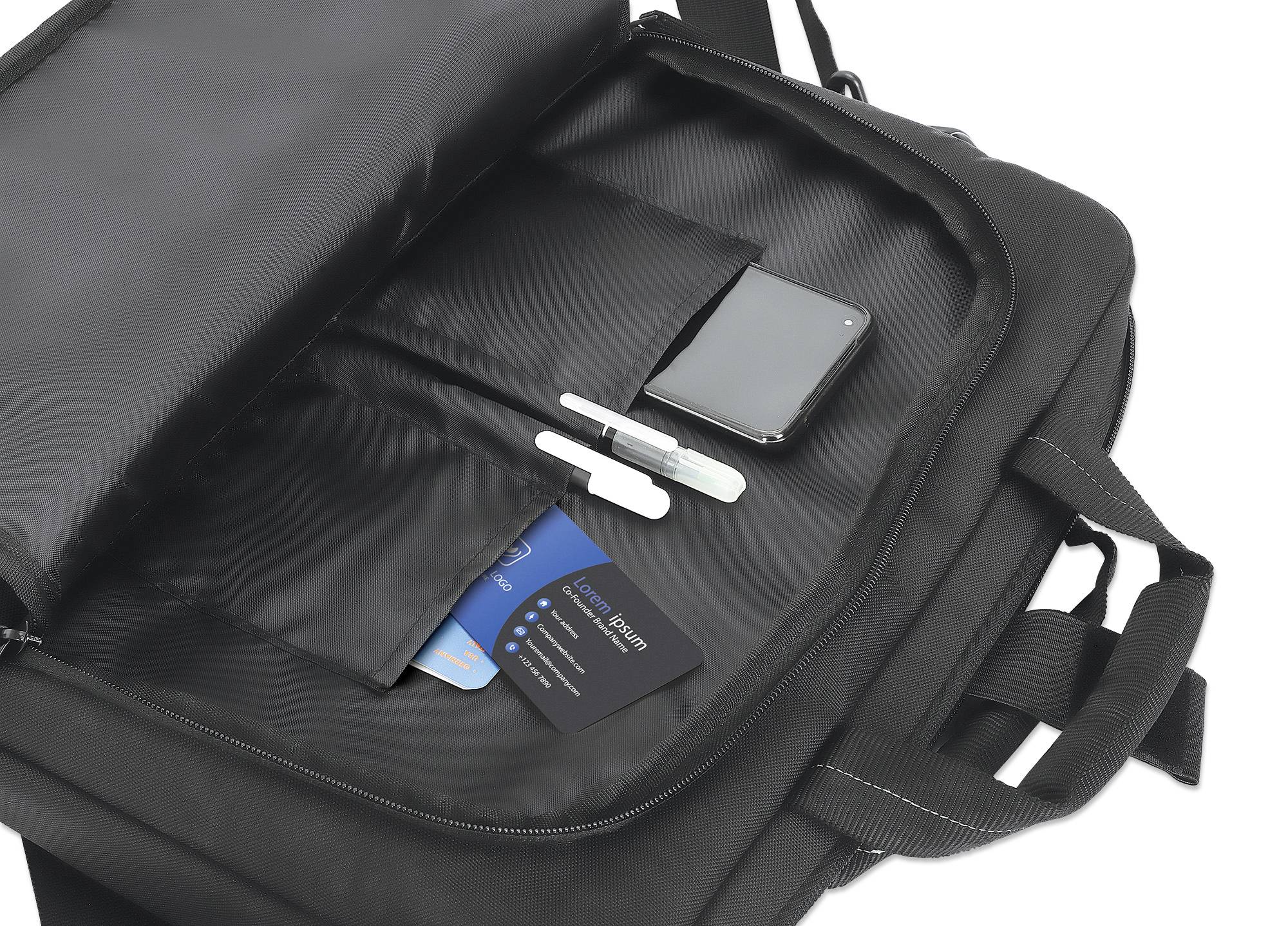 Un sac noir ouvert révèle des compartiments contenant un smartphone, deux stylos, une carte de crédit et une carte d'identité.