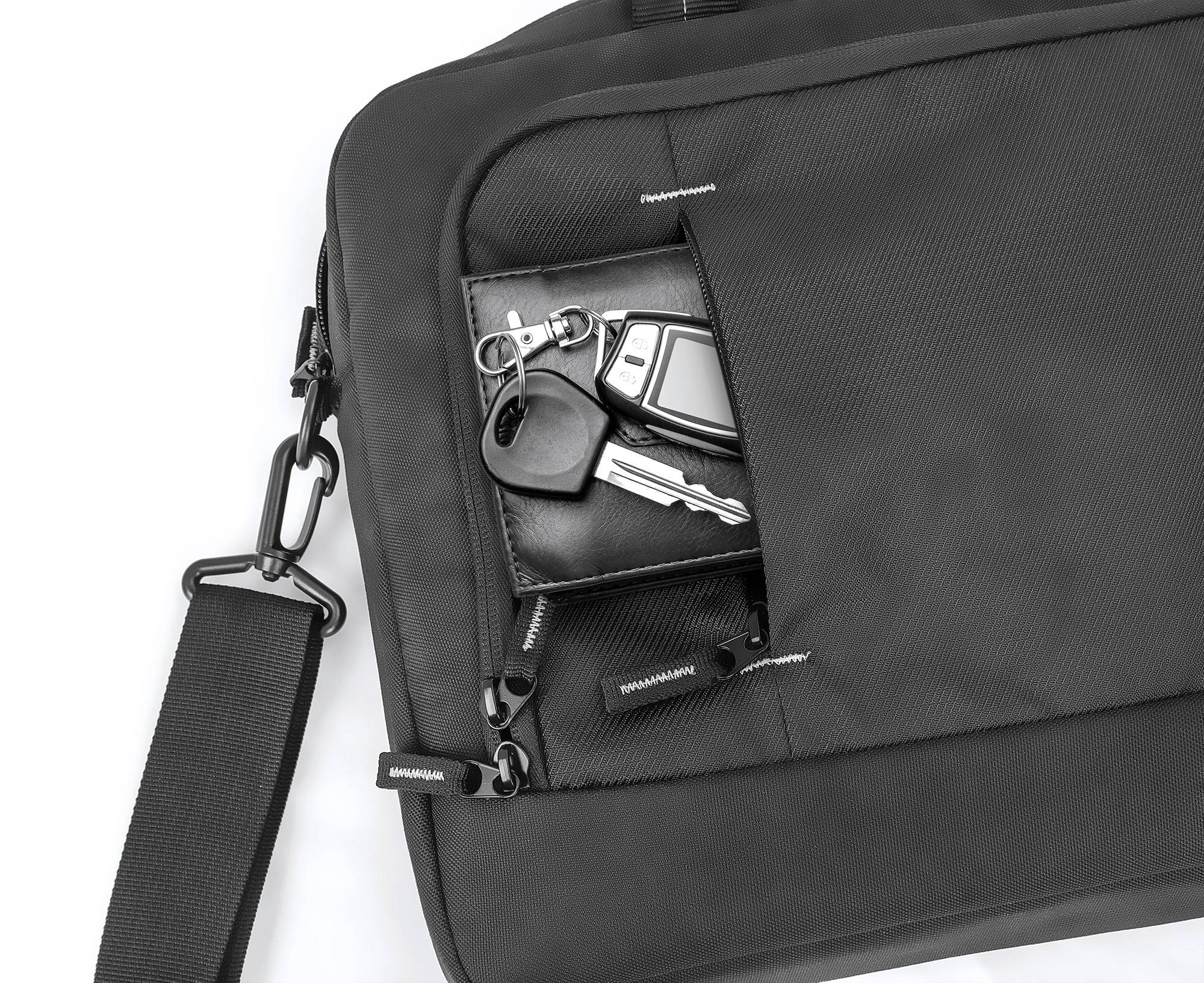 Un sac à bandoulière noir avec une pochette à fermeture éclair ouverte, d'où dépasse un trousseau de clés comprenant une clé de voiture.