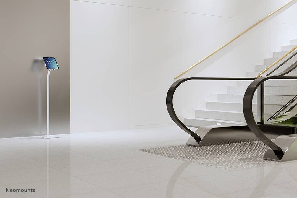 Hall d'accueil moderne avec un escalier roulant et un présentoir d'information numérique à droite. Design élégant avec un sol clair.