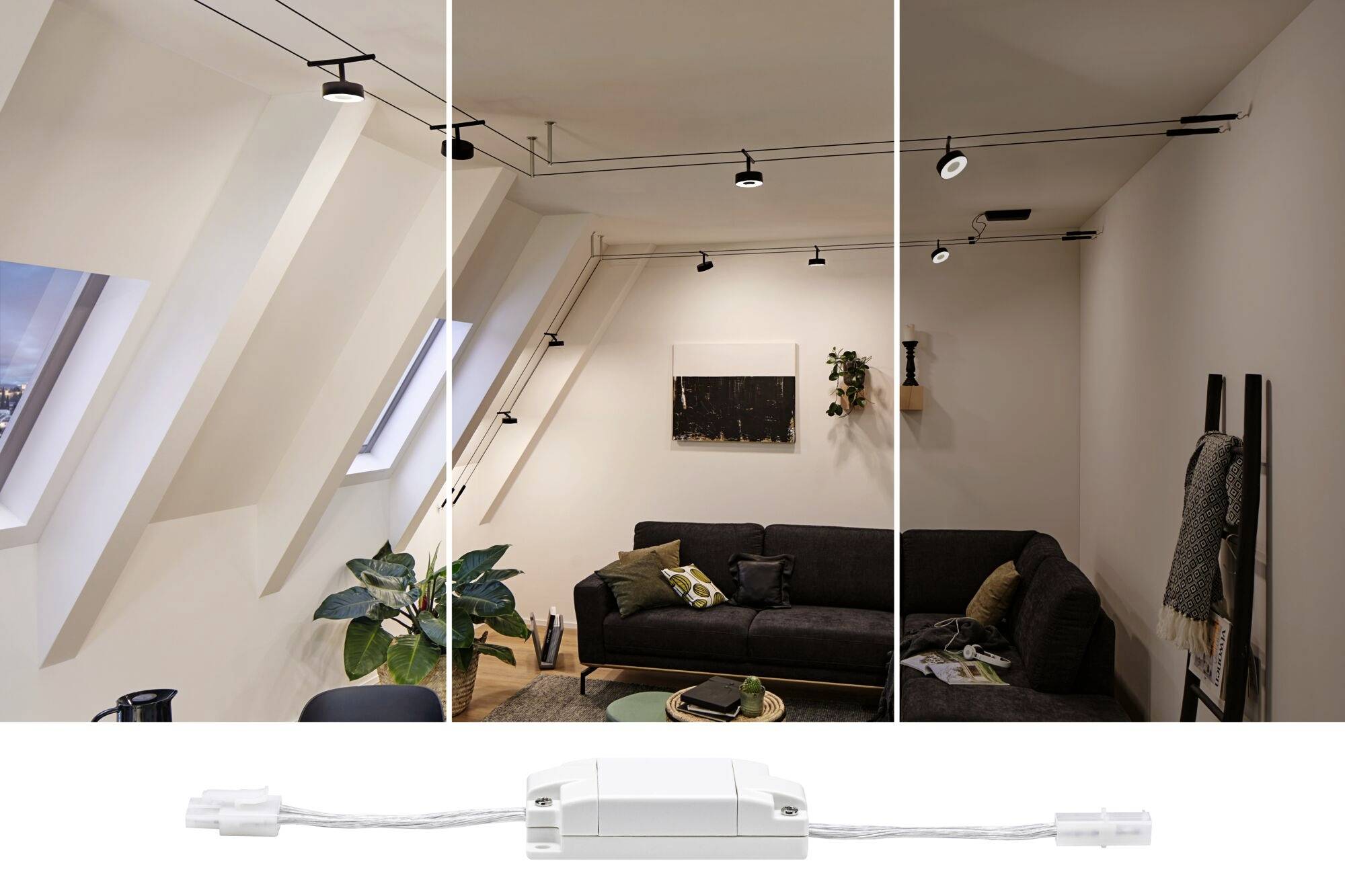 Salon avec canapé et plantes sous une fenêtre de toit inclinée. Plusieurs luminaires suspendus éclairent la pièce, dont un dispositif de commande.