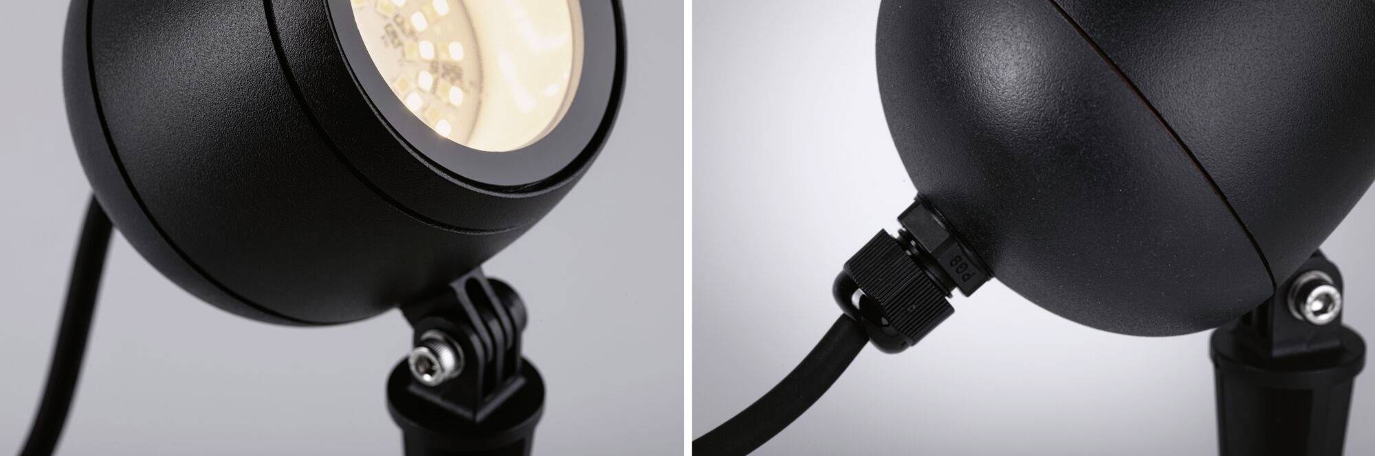 Gros plan d'une lampe LED moderne noire, de forme sphérique, montée sur un support articulé. Le câble de connexion est visible.