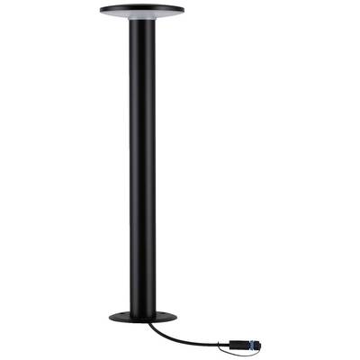 Lampadaire noir, haut et cylindrique, avec un abat-jour rond au sommet ; un câble avec une fiche est visible à la base.