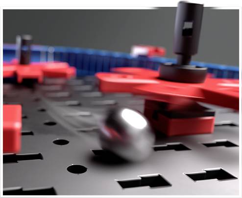 Gros plan d'un jeu de plateau de navires avec un plateau gris et des pions de navires rouges, avec une boule argentée visible.