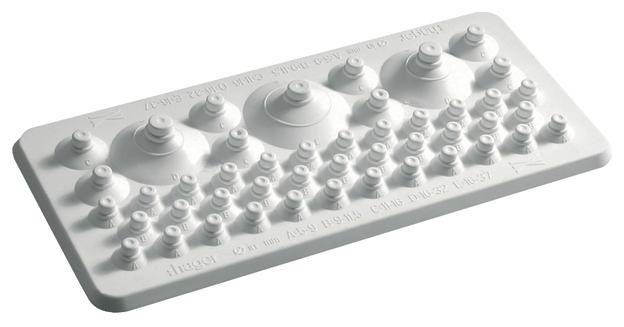Une feuille de film à reliefs blancs comme aide à l'apprentissage du braille, avec différentes formes et dispositions de reliefs pour s'entraîner à la dextérité des doigts.