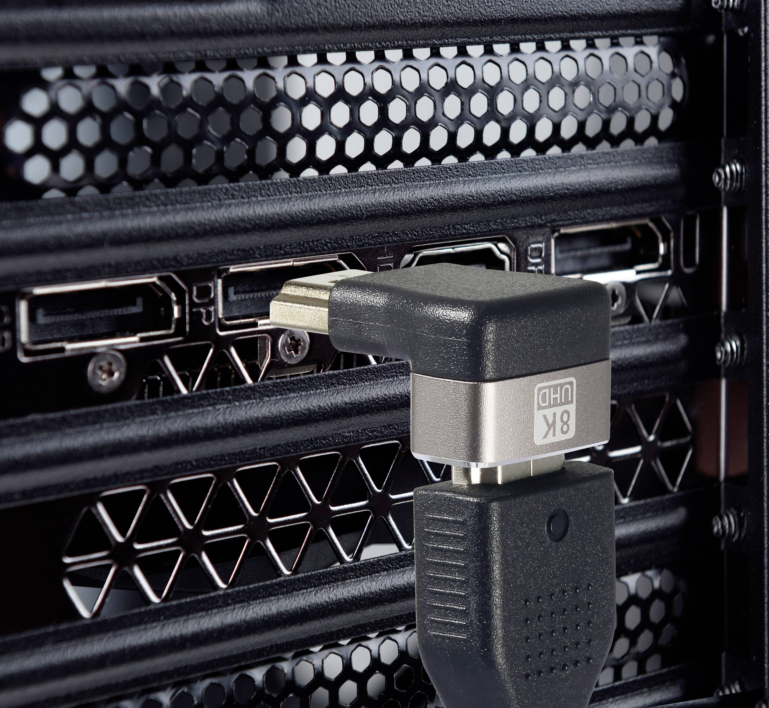 Un câble HDMI est branché dans un boîtier d'ordinateur équipé de fentes de ventilation. La connexion assure la transmission d'image.