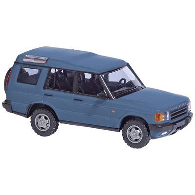 Une voiture miniature bleue tout-terrain, vue de côté. Elle montre des détails tels que les roues, les fenêtres et un design de carrosserie distinctif.