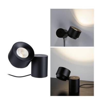 Une lampe noire, de forme cylindrique, montée sur une table et un mur. Mise en valeur de l'orientation flexible de la lumière.
