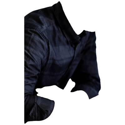 Un torse vêtu de noir, sans tête ni mains, qui sont absentes. Le focus est mis sur la chemise noire et les bras repliés.