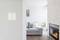 Salon avec un canapé gris, une cheminée moderne et une touche de verdure végétale. Un petit appareil discret est installé sur le mur.