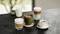Cinq spécialités de café différentes et un verre de lait sont posés sur une table ; une sélection colorée de boissons.