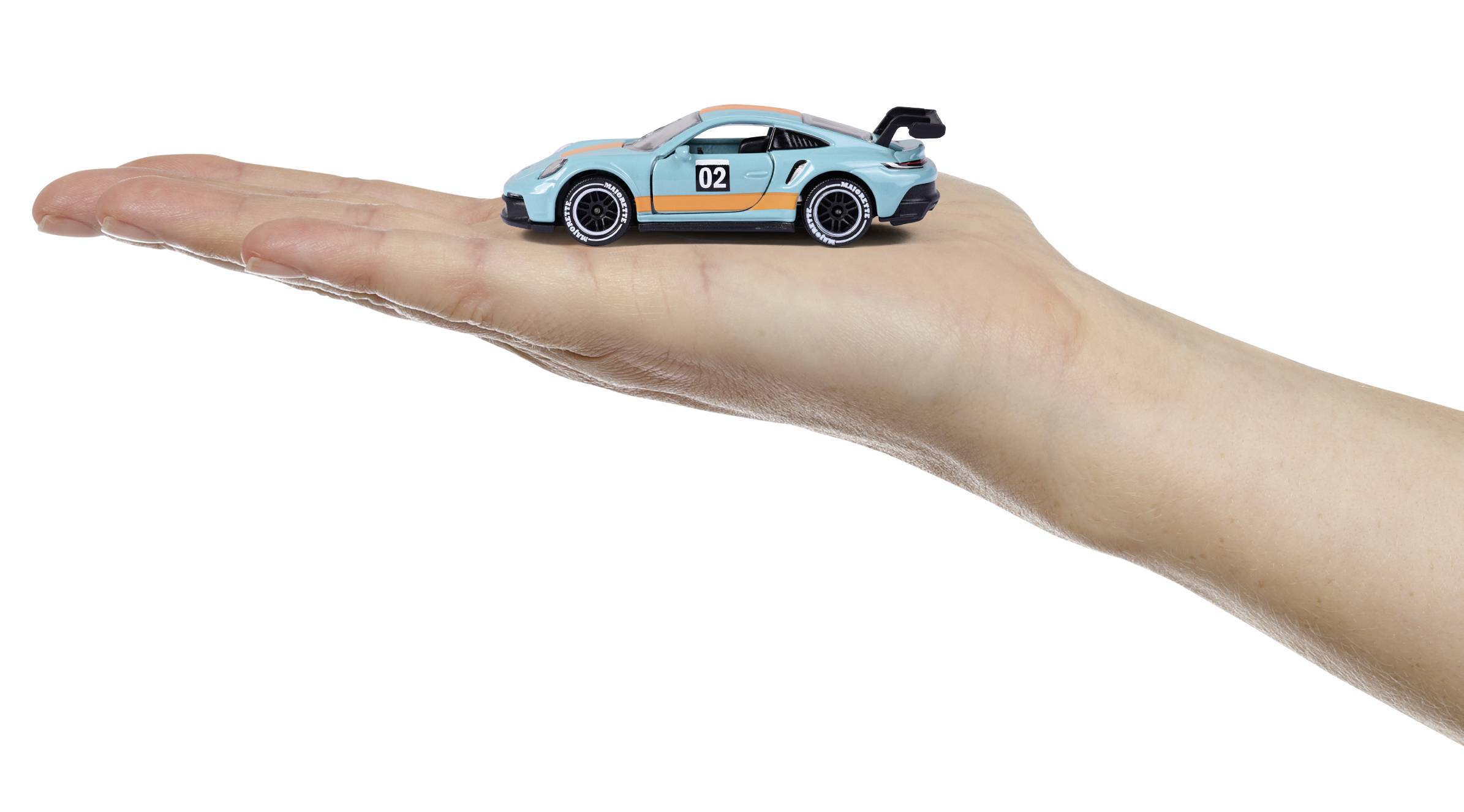 Une petite voiture de course bleue en jouet est posée sur une main tendue. La voiture porte le numéro '02' sur le côté.