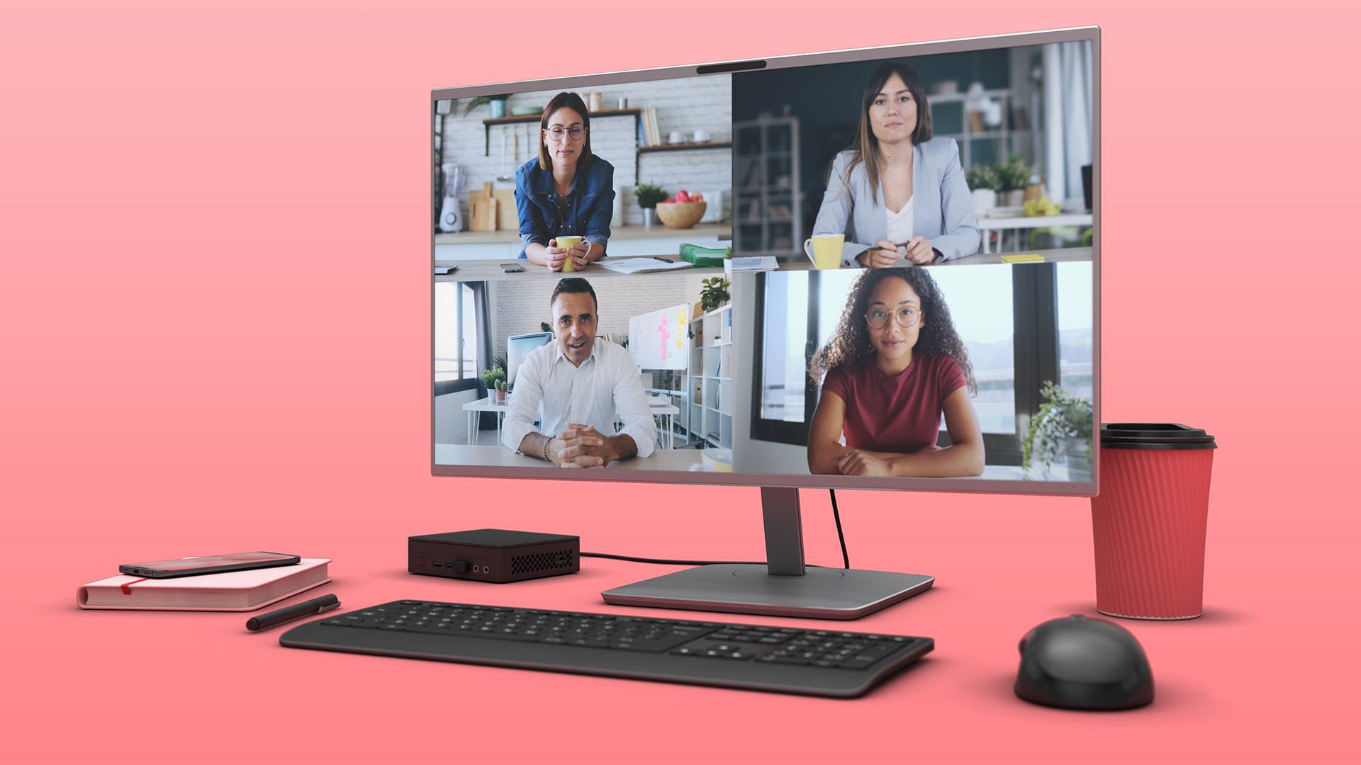 Quatre personnes lors d'une réunion virtuelle sur un écran d'ordinateur posé sur un bureau avec un clavier et une tasse de café.