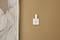 Mur avec un motif moderne à gauche et interrupteur blanc sur une surface beige à droite. Design minimaliste.