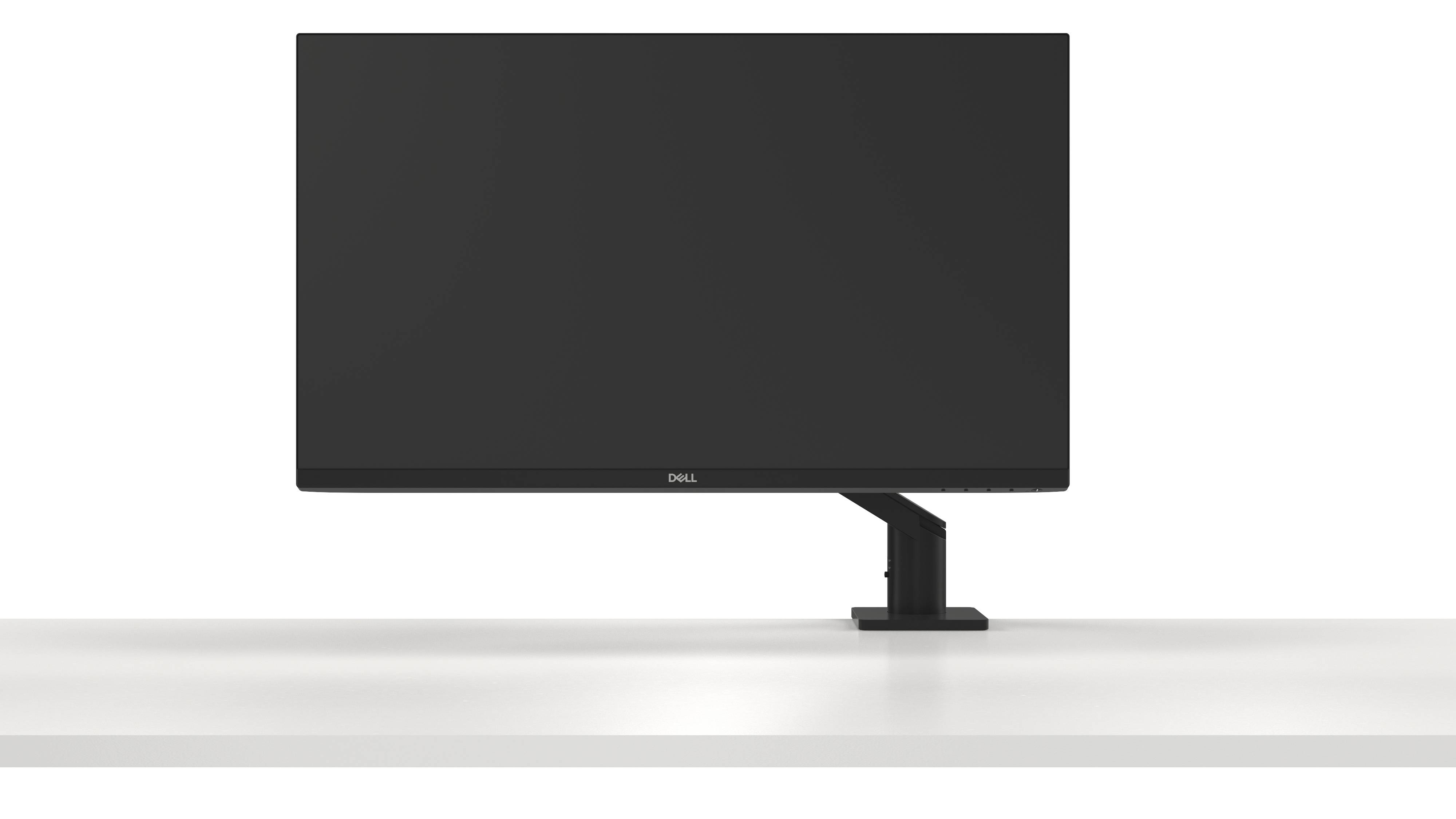 Un écran d'ordinateur noir avec un fin cadre est posé sur une table blanche. L'écran est éteint.