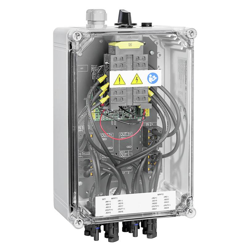 Une armoire électrique de commande avec un boîtier transparent. Les câblages internes, les interrupteurs et les avertissements sont visibles. Des marquages sont présents sur les interrupteurs et les composants.