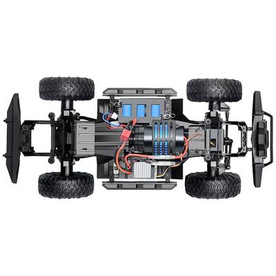 Vue de dessus d'une voiture télécommandée montrant sa structure interne avec moteur, câblage et batterie. Les roues sont clairement visibles.