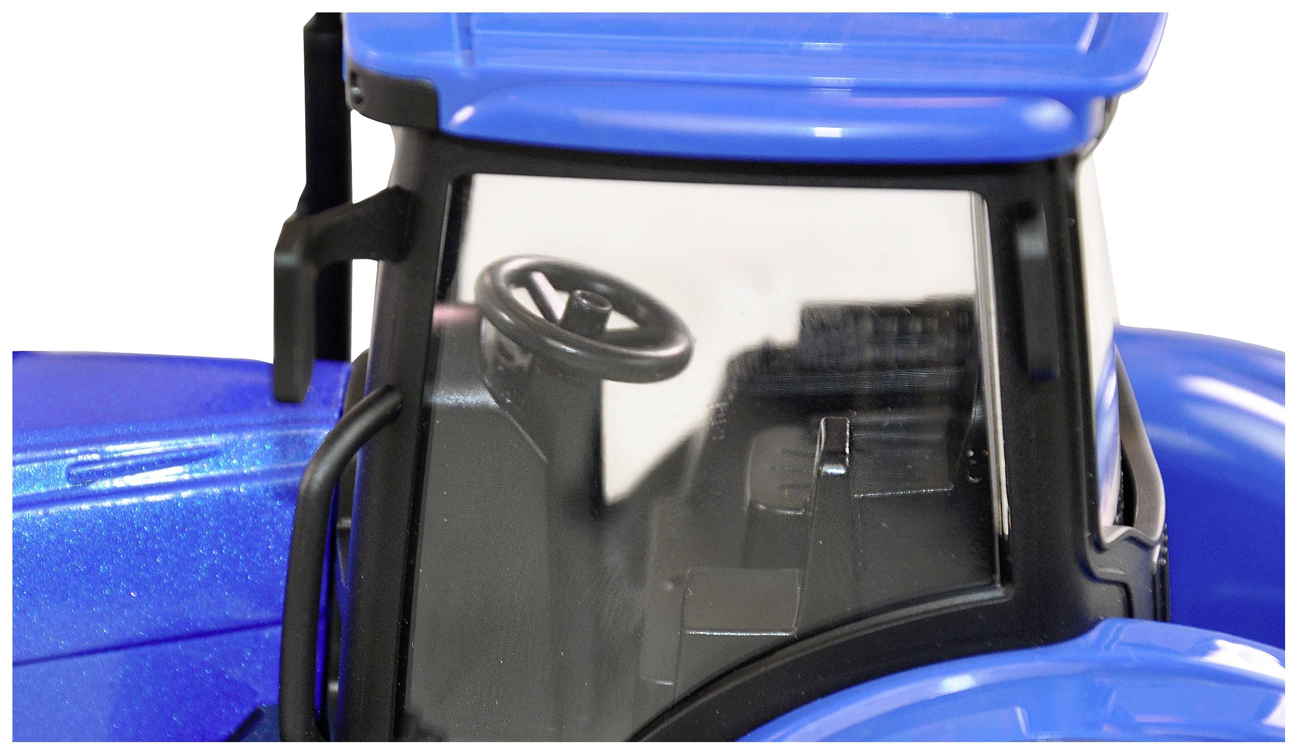 Gros plan d'un tracteur jouet bleu avec le volant visible à travers le pare-brise.