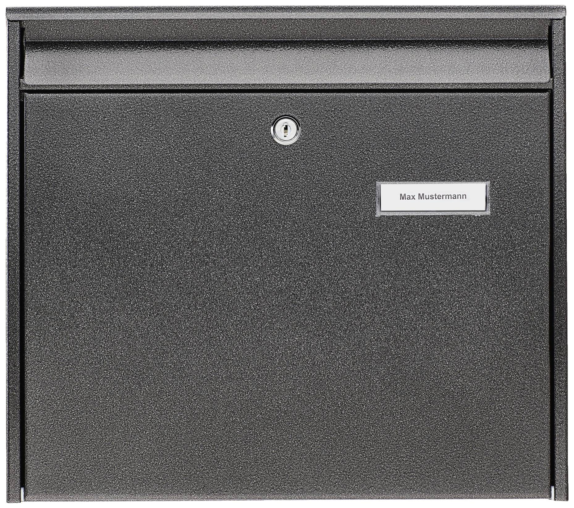 Boîte aux lettres noire avec plaque nominative. Le nom 'Max Dupont' est inscrit sur la plaque.