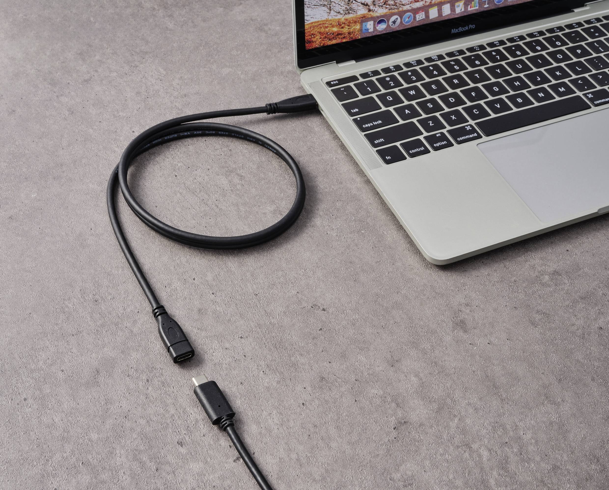Un ordinateur portable est posé sur une table, connecté par un câble HDMI qui repose à côté. Cette scène illustre une configuration technique.