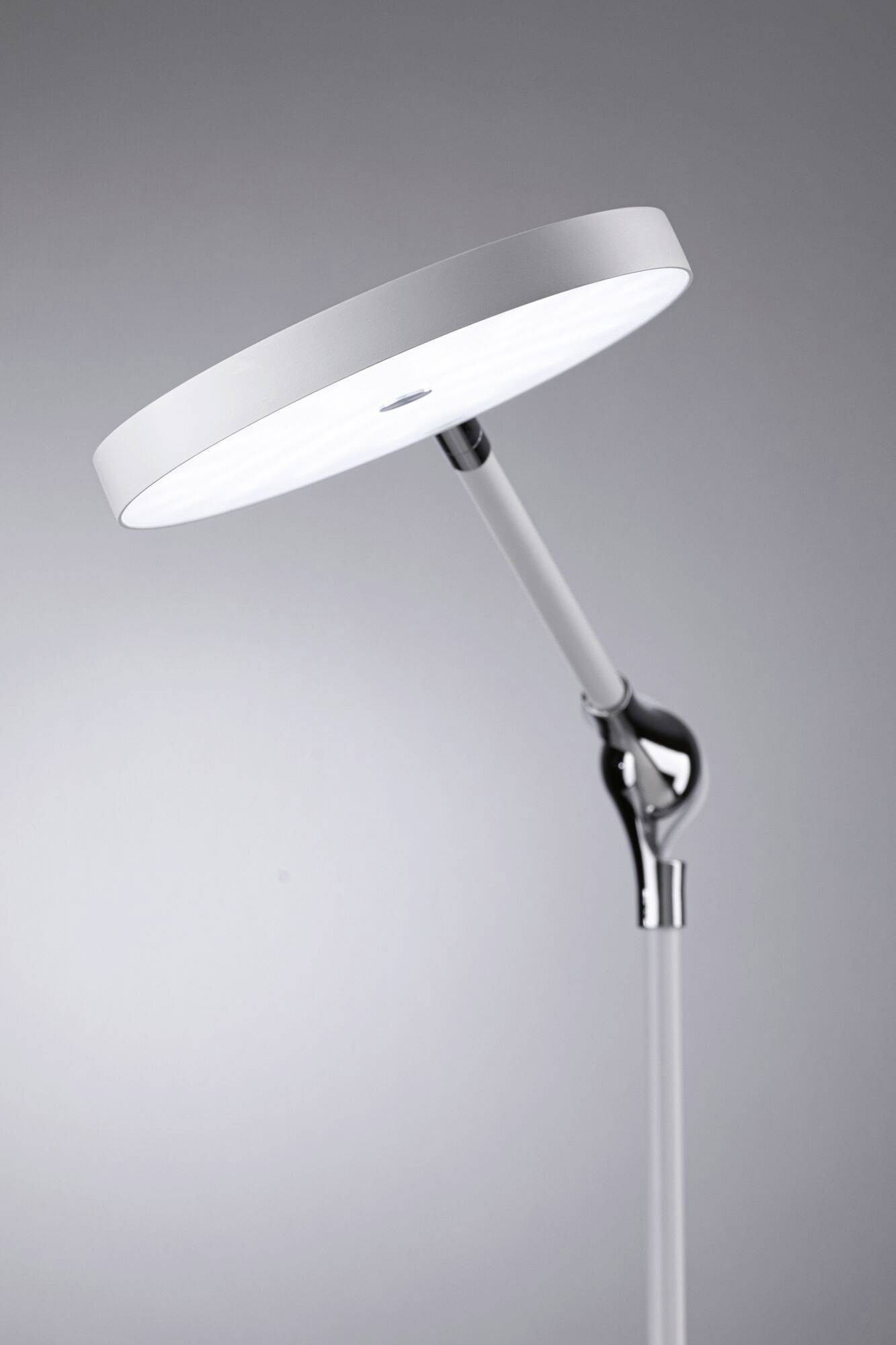 Une lampe sur pied LED moderne et ronde, au design épuré et minimaliste, présente un abat-jour incliné monté sur un bras pivotant.
