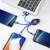 Un ordinateur portable est connecté à trois smartphones via un câble USB multifonctionnel doté de ports USB et Lightning.