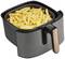 Friteuse avec un récipient rempli de frites dorées et croustillantes. Un appareil de cuisine noir est visible en arrière-plan.