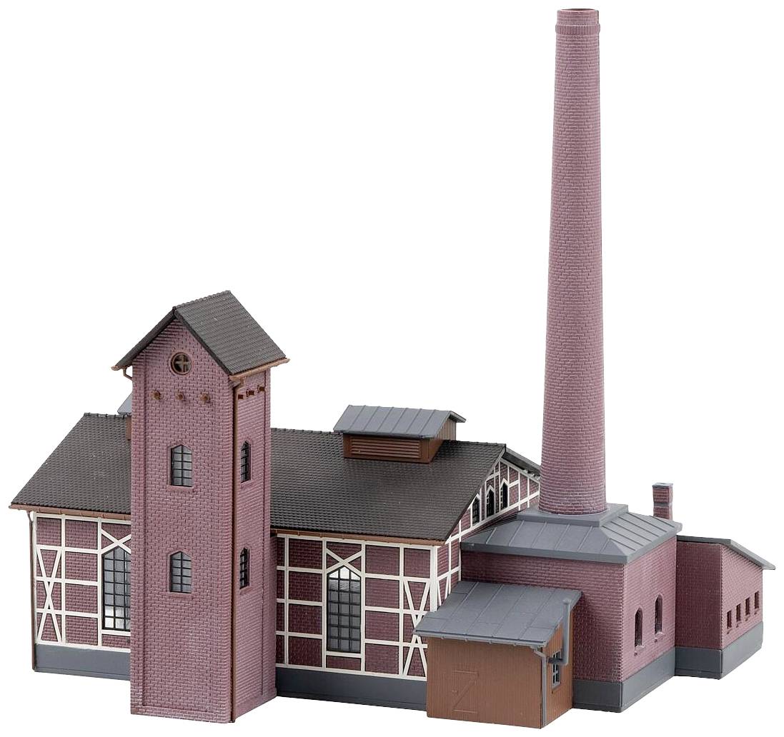 Un modèle d'une installation industrielle avec un bâtiment en briques rouges, une haute cheminée et une tour. Architecture typique du début du XXe siècle.