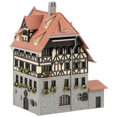 Maison à colombages avec des tuiles rouges et des jardinières aux fenêtres. Architecture de style traditionnel.