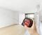 Une personne mesure la surface d'un appartement moderne et vide avec un télémètre laser.