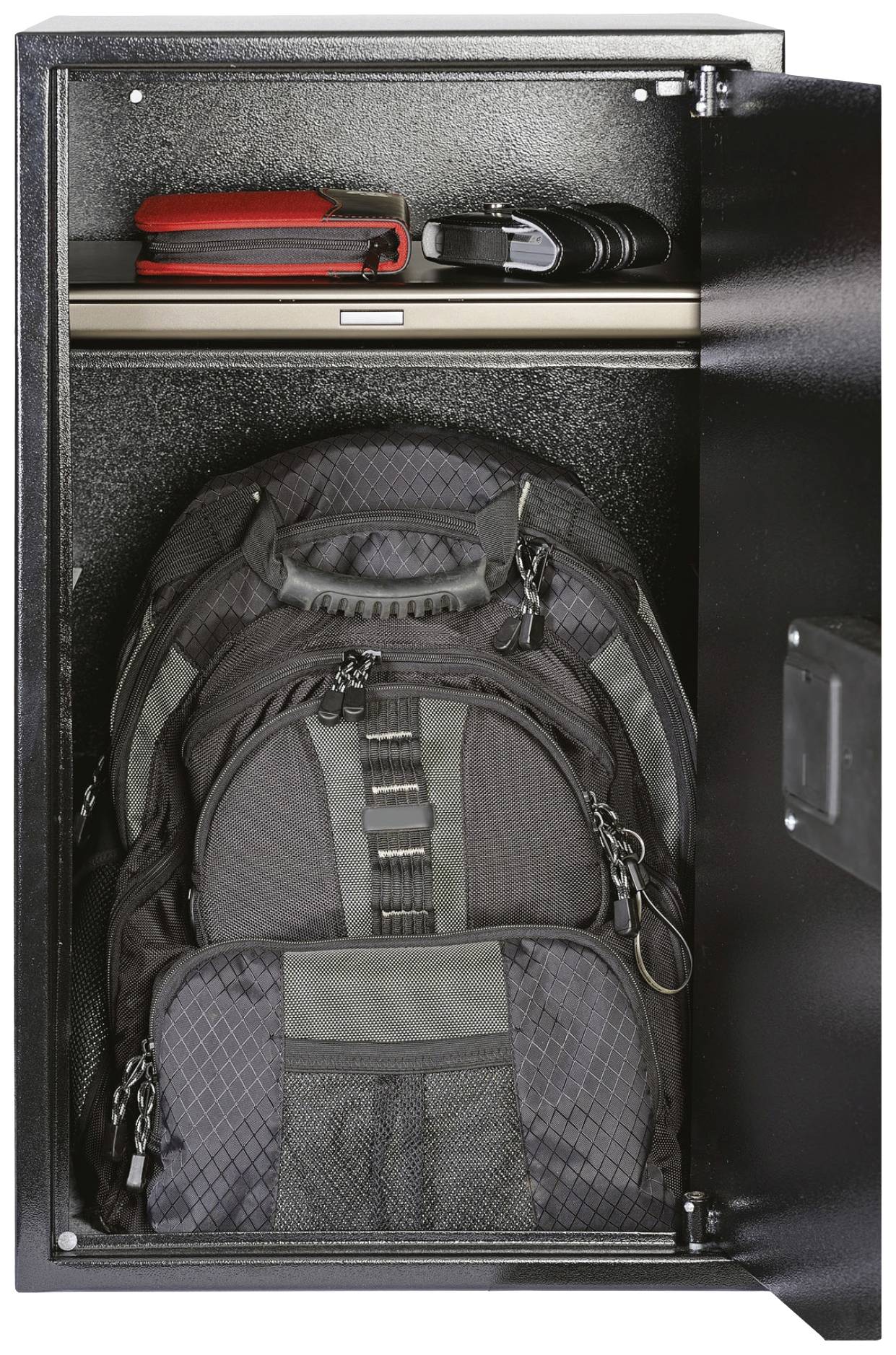 Un placard ouvert avec un grand sac à dos noir en bas, un ordinateur portable et un sac sur l'étagère supérieure.