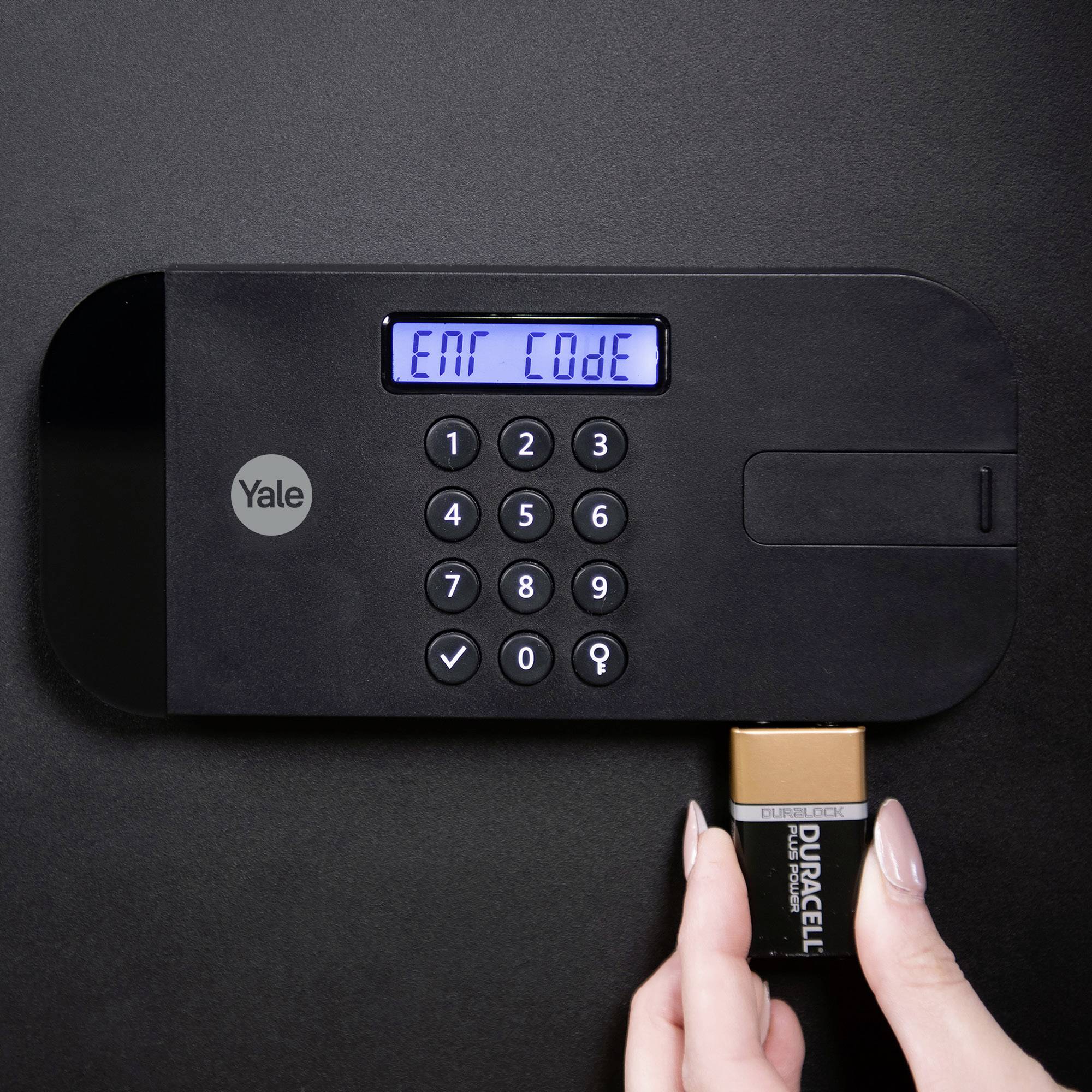 Serrure électronique avec clavier et écran affichant 'Ent Code'. Une main remplace une pile.