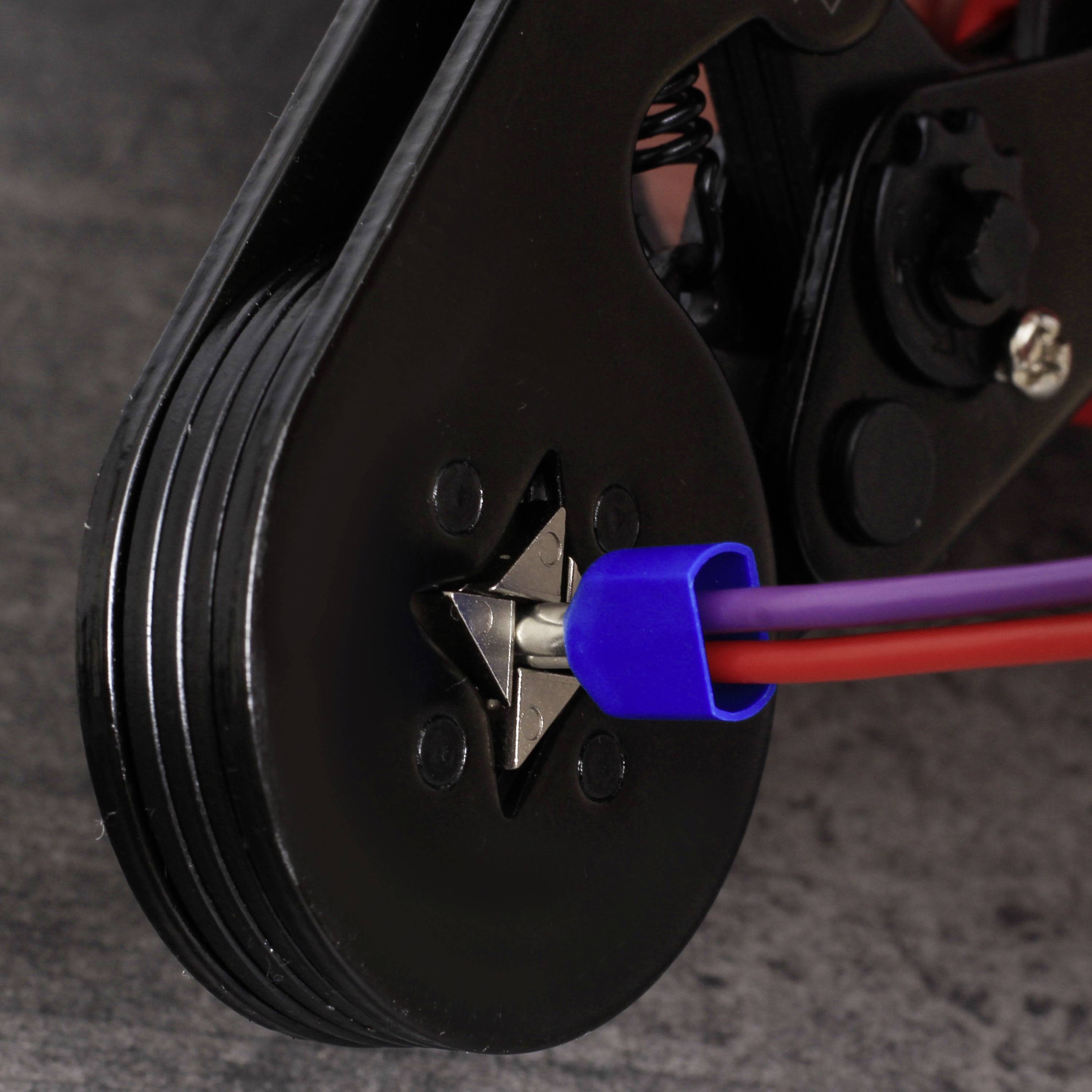 Une image détaillée d'une roue noire en forme d'étoile avec un câble bleu enroulé autour d'un rouleau.