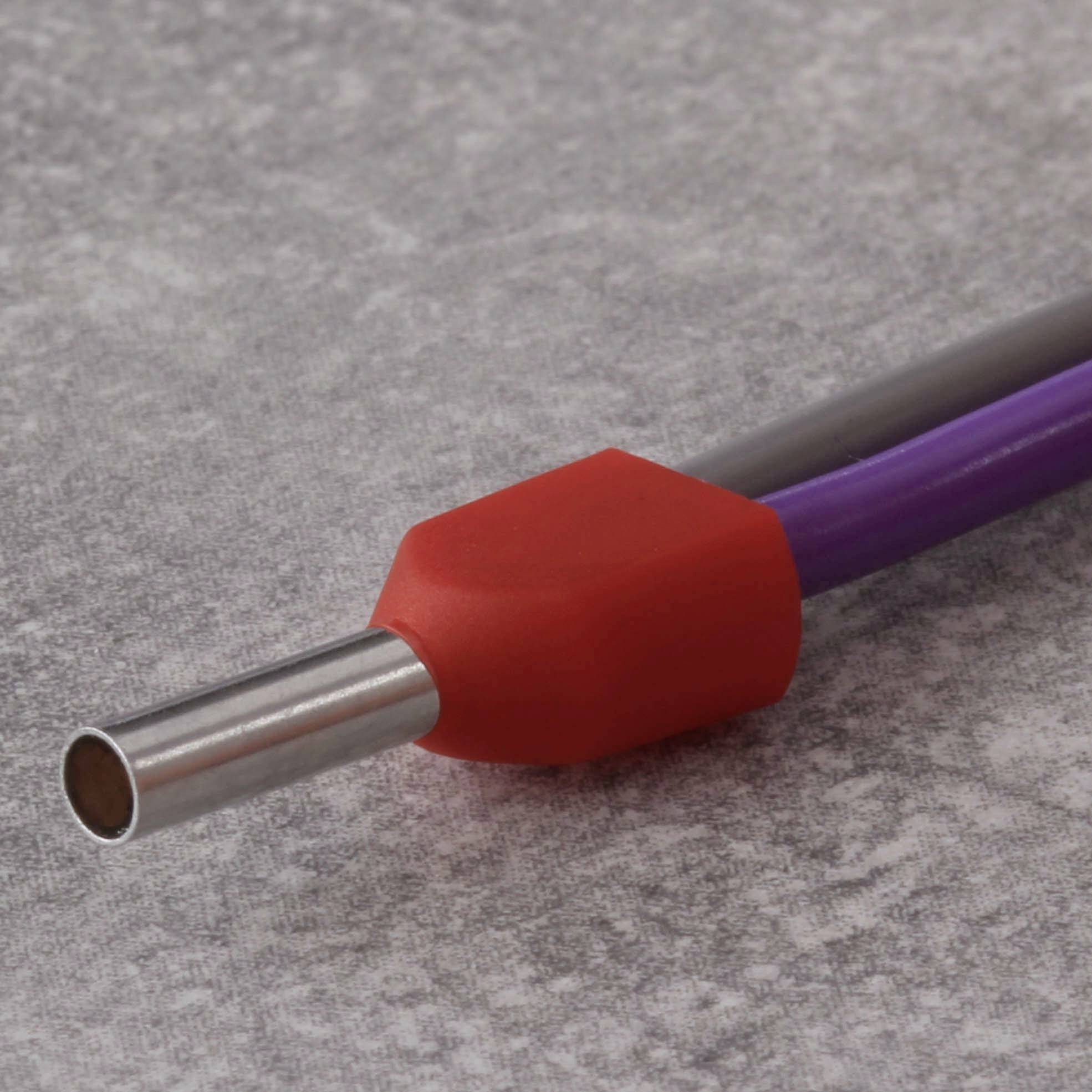 Tuyau métallique et tuyau flexible en plastique violet avec revêtement de protection rouge, reposant sur une surface grise.
