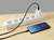 Un smartphone est posé sur une table et se charge via un câble branché à une multiprise. L'écran affiche 'Charging'.