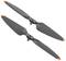 Deux hélices de drone noires avec des pointes orangées sur un fond blanc.