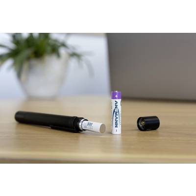 Une batterie rechargeable est posée sur une table à côté d'un appareil à piles, d'un boîtier de batterie ouvert et d'une plante en arrière-plan.