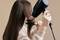Une personne sèche ses longs cheveux lisses avec un sèche-cheveux noir tout en les coiffant avec une brosse ronde.
