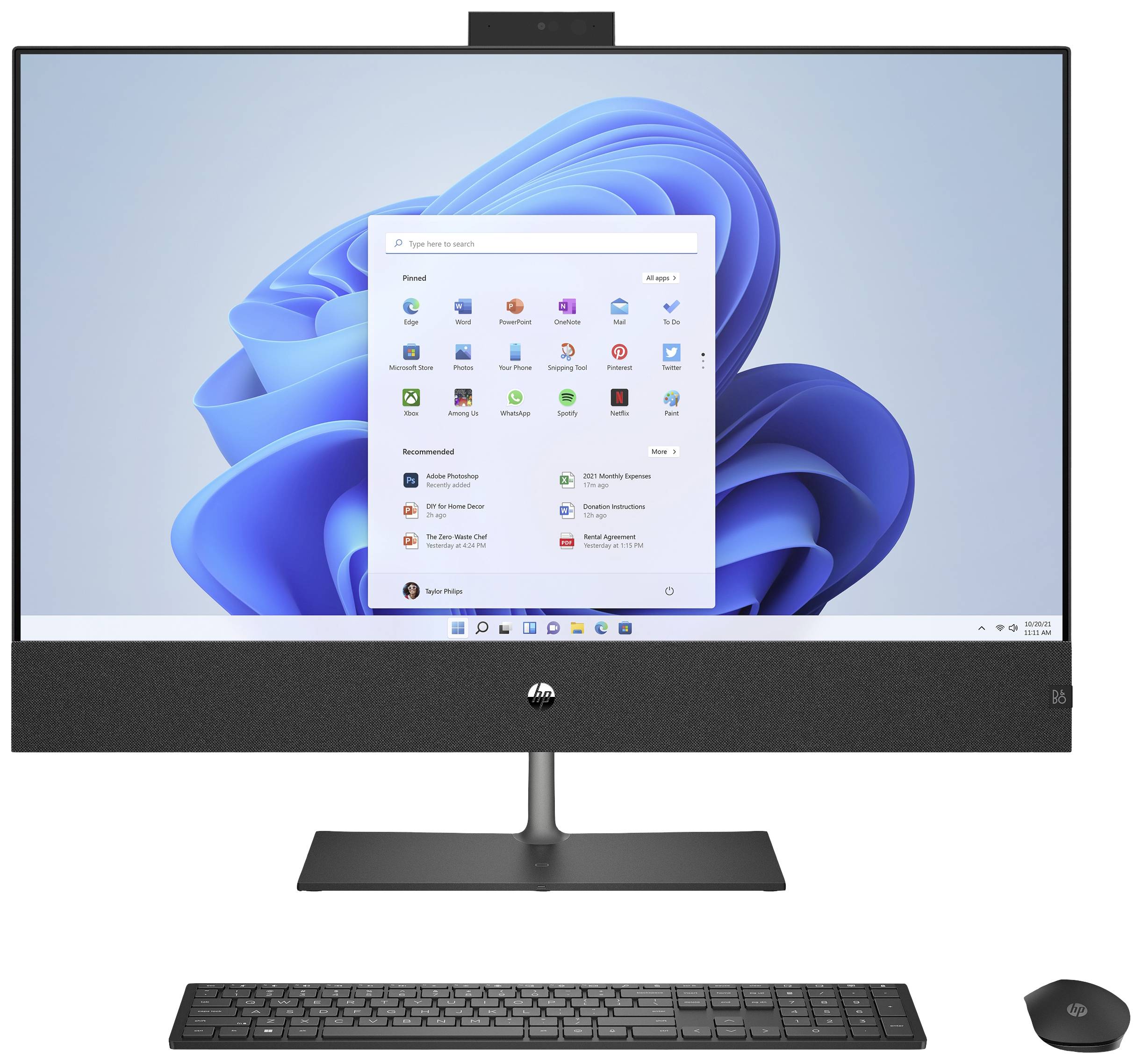 Ordinateur tout-en-un avec écran allumé, affichant l'écran de démarrage de Windows. Clavier et souris devant l'ordinateur.