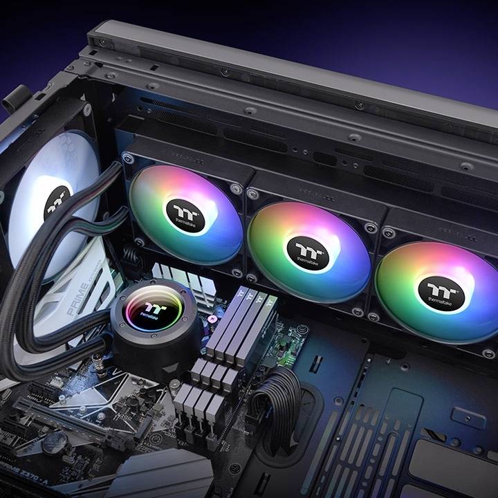 Un ordinateur ouvert montre une carte mère équipée d'un système de refroidissement à eau et de ventilateurs RGB lumineux de différentes couleurs.