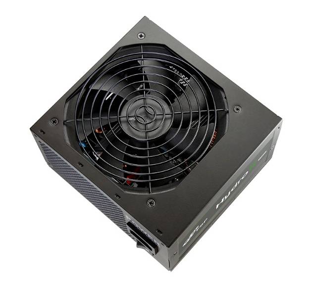 Bloc d'alimentation d'ordinateur noir avec ventilateur intégré, photographié en plongée, montrant les connexions de câbles et les fentes de ventilation.