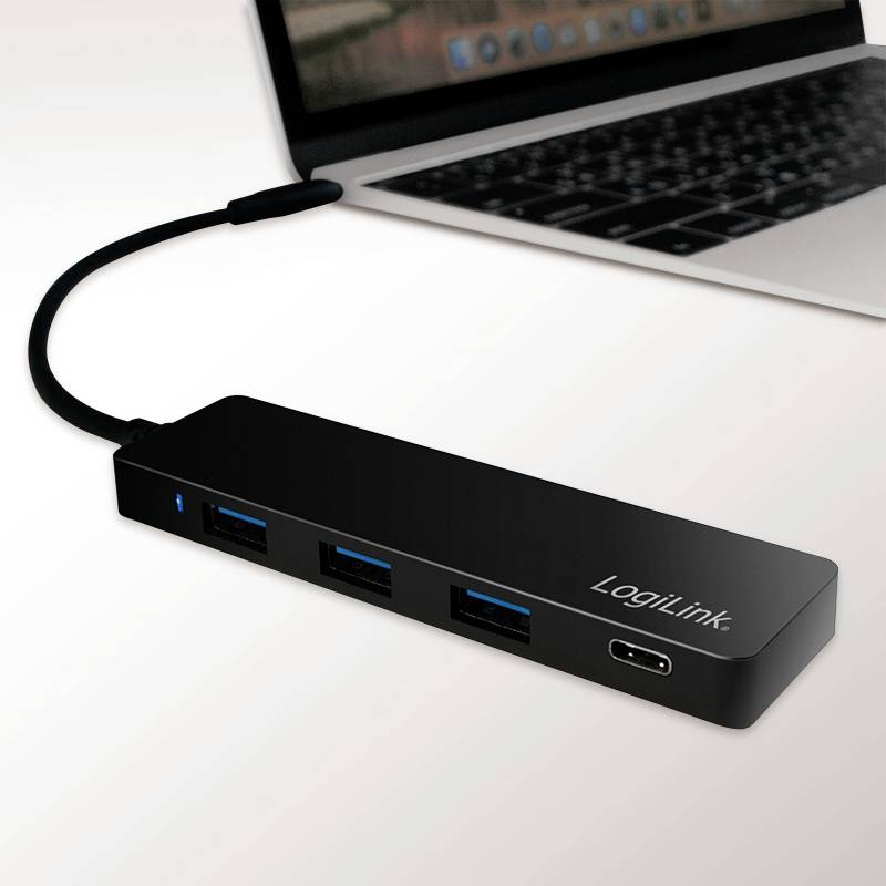 Un hub USB noir avec plusieurs ports est connecté à un ordinateur portable.
