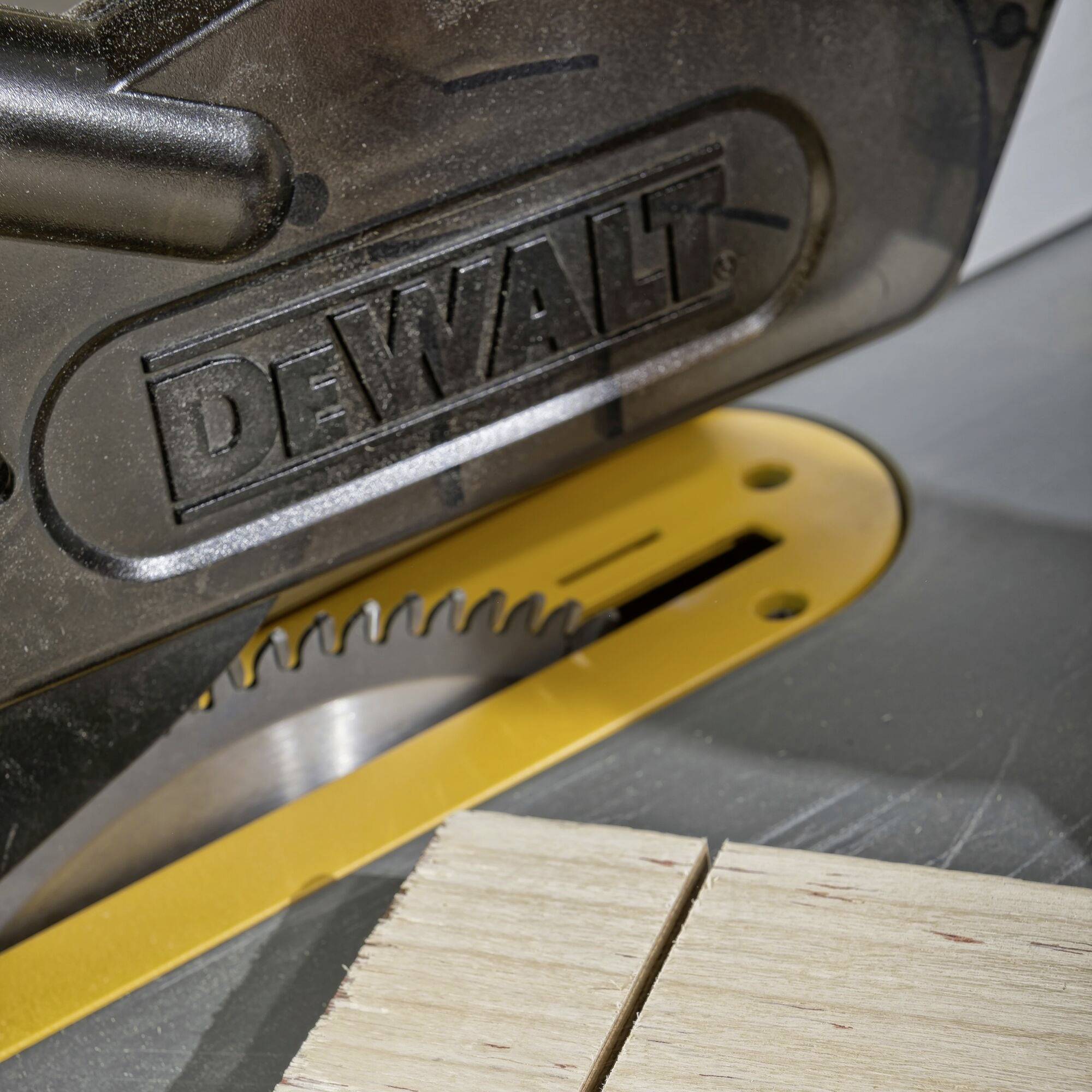 Scie circulaire avec le logo 'DEWALT' sur le carter de protection, en train de couper une planche de bois.