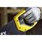 Une personne portant des gants de travail tient une scie avec une poignée jaune, prête à être utilisée.