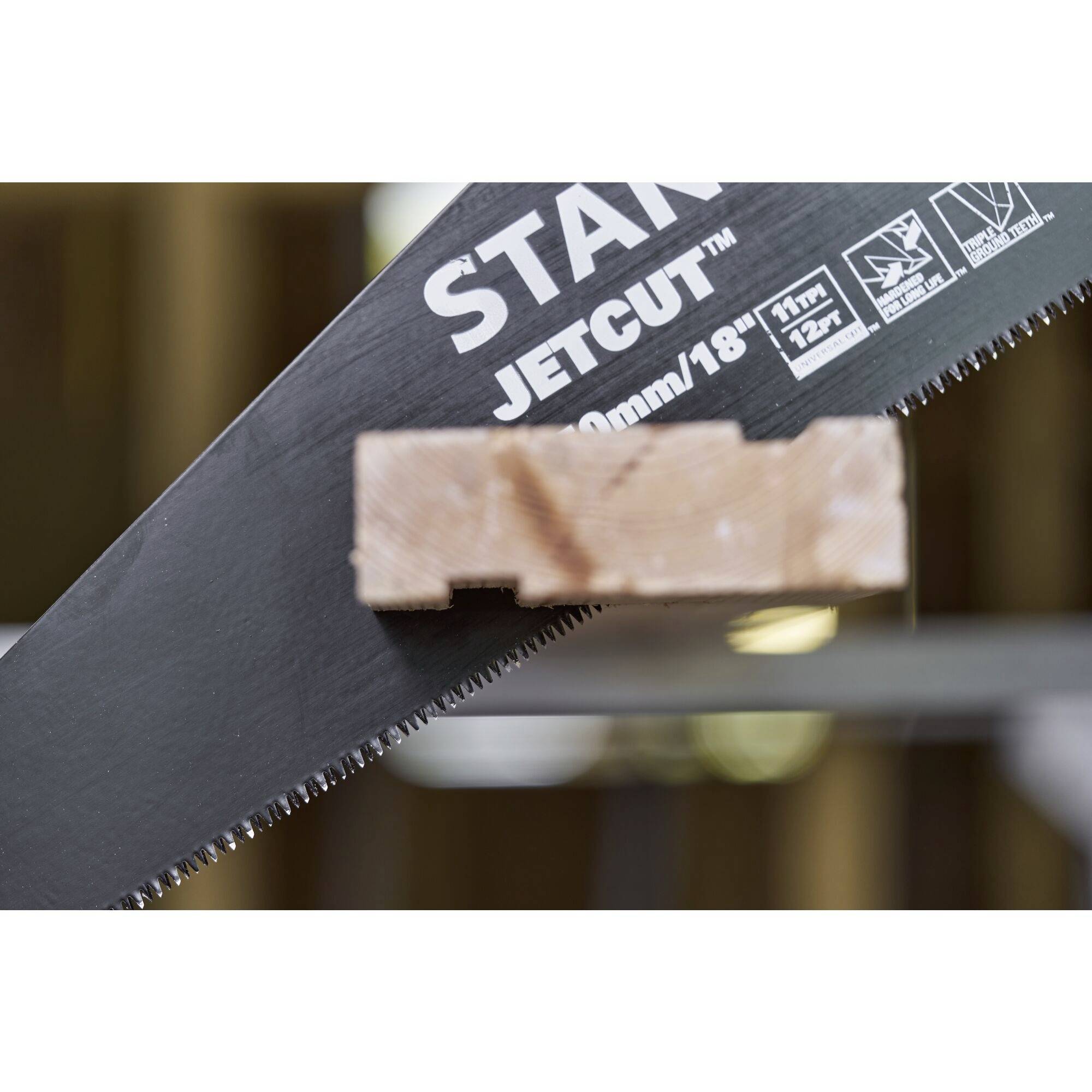 Gros plan sur une scie portant l'inscription 'JETCUT'. Une latte de bois est maintenue par les dents de la scie.