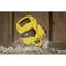 Un mètre ruban jaune et robuste posé sur un sol de gravier et de poussière, adapté pour des mesures précises dans des environnements de construction.