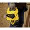 Une personne tient un ruban à mesurer jaune de la marque 'Stanley', long de 60 mètres, avec une poignée robuste, sur un fond de surface en bois.