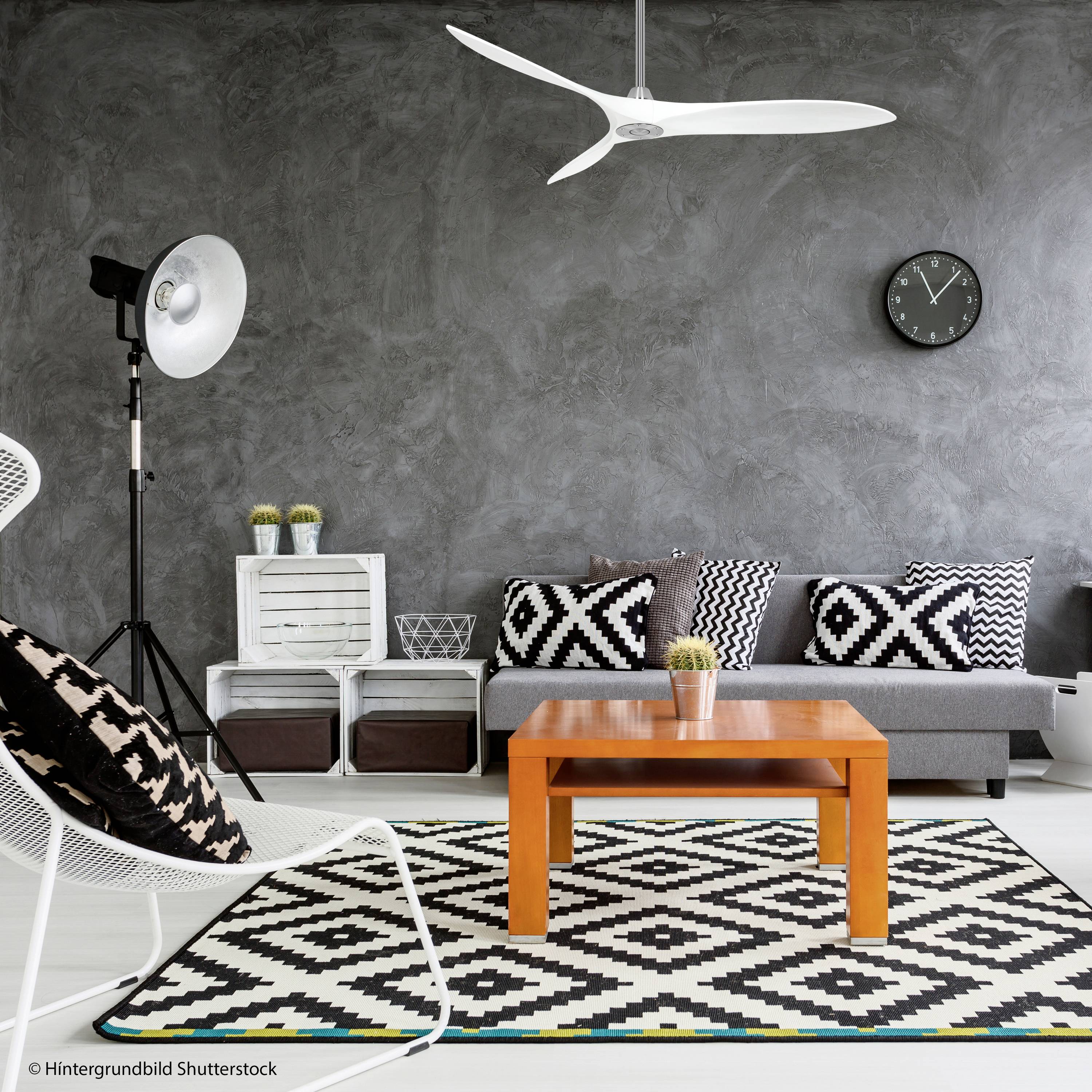 Salon moderne avec mur peint en gris, canapé avec coussins à motifs, table basse orange et tapis à motif noir et blanc.