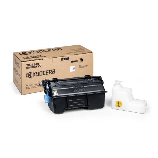 Cartouche 'Kyocera TK-3440', unité de toner noire à côté de son emballage. À gauche, un carton avec une inscription, à droite un récipient blanc.