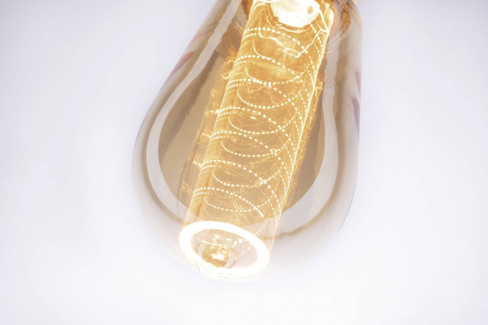 Une ampoule à filaments spiralés visibles brille intensément sur un fond blanc.